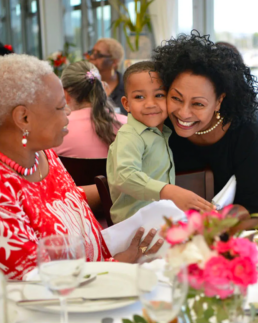Menbere Aklilu hugs a small boy at her Mother's Day Brunch event.
